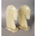 A LARGE PAIR OF CARVED OVAL HORSES HEAD BOOKENDS. 11ins high.