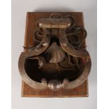 A LARGE 17TH CENTURY GERMAN DOOR KNOCKER on a wooden stand.