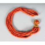 A FOUR ROW CORAL NECKLACE with silver gilt clasp.