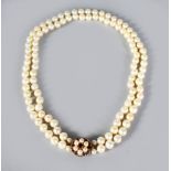 A TWO ROW PEARL NECKLACE with gold, amethyst and pearl clasp.