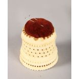 A 19TH CENTURY DIEPPE CARVED AND PIERCED BONE PIN CUSHION. 2ins high.