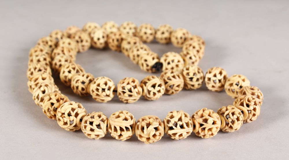 A PIERCED IVORY SPHERES NECKLACE.