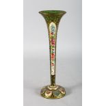 A TALL BOHEMIAN TAPERING GREEN GLASS TRUMPET VASE, with white enamel decoration and flowers. 12ins