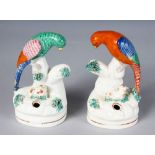 A PAIR OF STAFFORDSHIRE PEN HOLDERS, as colourful birds on a tree stump, with a tiny lamb. 5ins