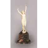 A EUROPEAN CARVED IVORY STANDING NUDE. 4.75ins high, on a triangular marble base.