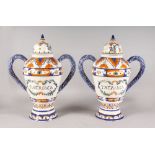 A LARGE PAIR OF THERIAC TWO HANDLED DRUG JARS AND COVERS in blue and orange. 19ins high.