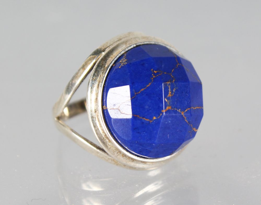 A SILVER AND LAPIS CUT RING.