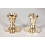 A PAIR OF STERLING SILVER PLAIN CIRCULAR CANDLESTICKS. 3ins high.