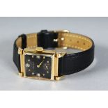 A 14K GOLD BULOVA LONGCHAMPS WRISTWATCH, with black face and three diamonds, on a leather strap.