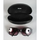 A PAIR OF PRADA SUNGLASSES, in a folding case.