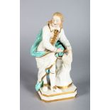 A "MEISSEN" PORCELAIN FIGURE OF A MAN holding a scroll and leaning on books. 10ins high.