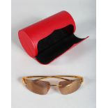 A PAIR OF CARTIER GOLD METAL PANTHER SUNGLASSES, in a red Cartier case.