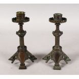 A PAIR OF ESTHETIC METAL CANDLESTICKS. 7.5ins high.