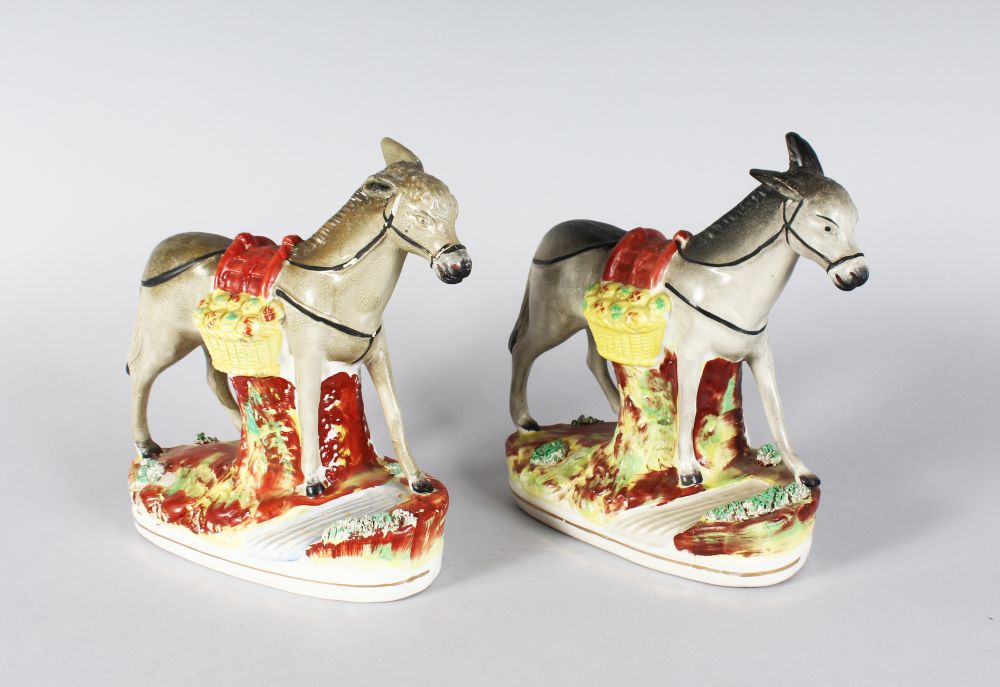 A PAIR OF STAFFORDSHIRE DONKEYS. 8ins high.