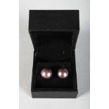 A PAIR OF BLACK PEARL AND GOLD EAR STUDS.