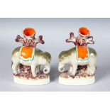 A PAIR OF STAFFORDSHIRE "ELEPHANT" SPILL VASES with an elephant standing before a tree. 7ins high.