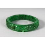 A CHINESE CARVED GREEN JADE BANGLE.