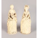 A VERY GOOD PAIR OF 19TH CENTURY CARVED IVORY FIGURES OF WOMEN wearing ball gowns. 9ins high.