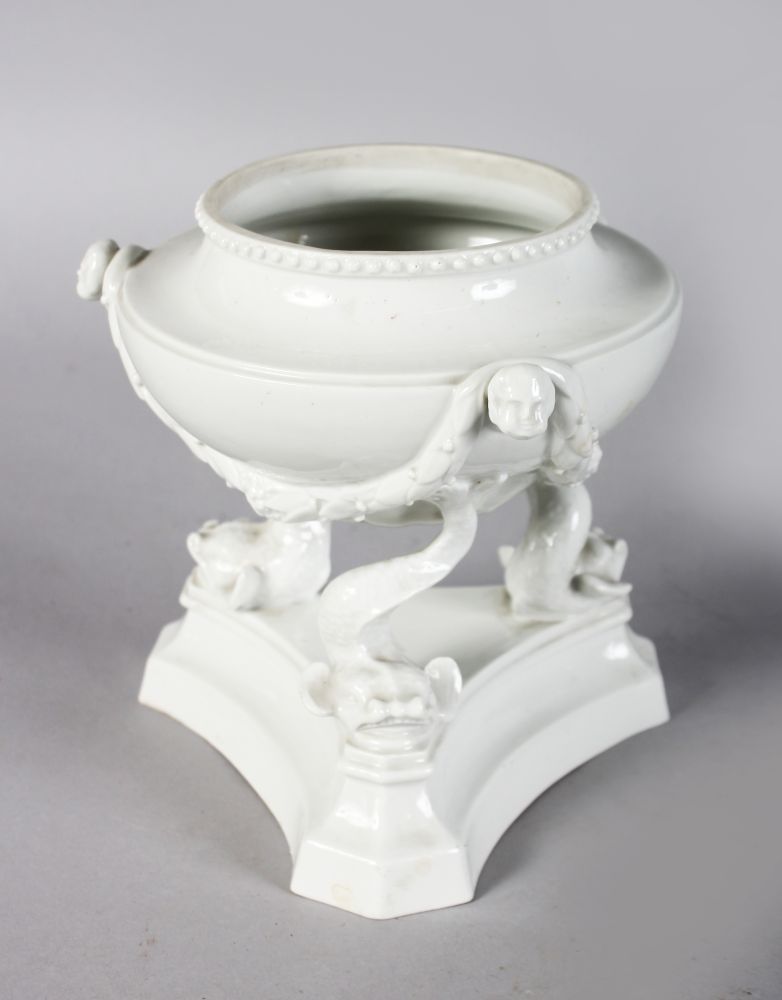 AN 18TH CENTURY FURSTENBERG VASE supported by three fish tails, in the white with swags and human