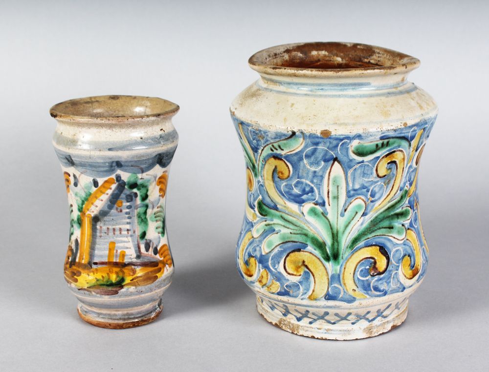 AN ITALIAN COLOURED POTTERY DRUG JAR, and a smaller drug jar. 8ins and 6ins high.