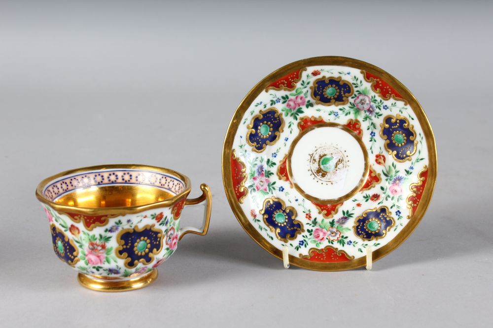 A FRENCH CUP AND SAUCER painted with flowers.