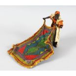 AN AUSTRIAN COLD PAINTED ARAB HOLDING A CARPET. 9ins long.