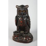 A CARVED WOOD BLACK FOREST OWL TOBACCO JAR with folding head and glass eyes. 11.5ins high.