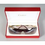 A PAIR OF CARTIER SUNGLASSES in original box.