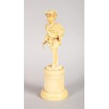 A GOOD EUROPEAN CARVED IVORY FIGURE OF A BOY carrying a sickle, standing on a pedestal. 6.5ins