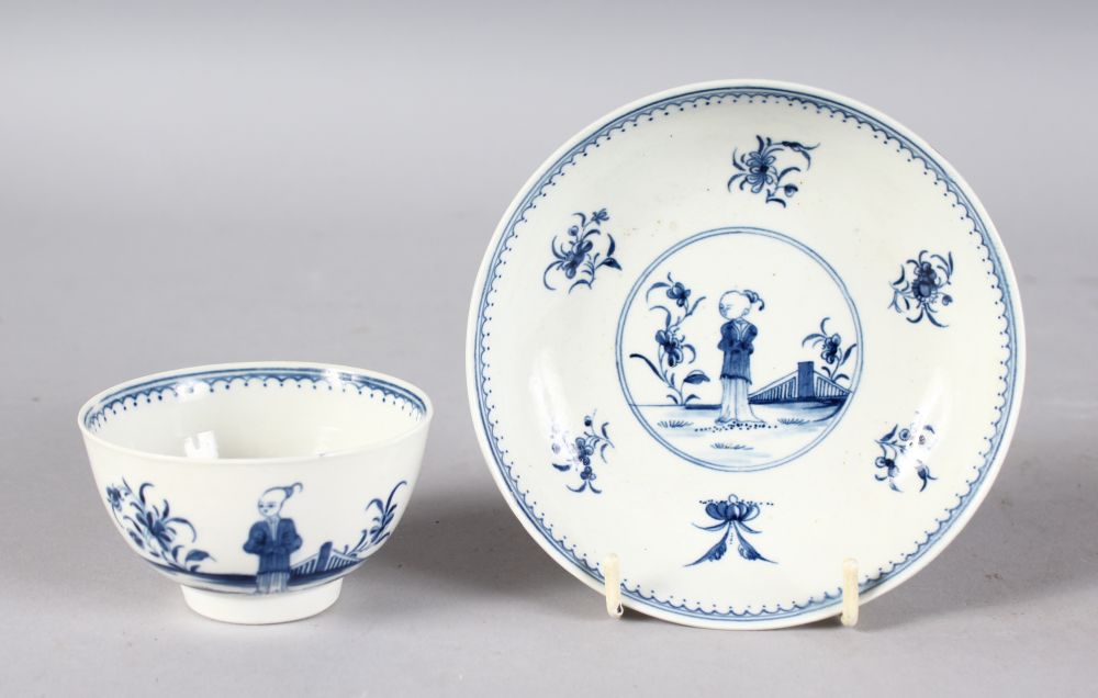 AN 18TH CENTURY WORCESTER TEA BOWL AND SAUCER painted in under-glaze blue with the Waiting