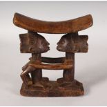 A CARVED WOOD TRIBAL STOOL HEADREST. 7ins high.