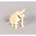 A GOOD EUROPEAN IVORY FIGURE OF A SEATED DOG with hardstone eyes. 1.25ins high.