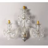 A CUT GLASS WALL LIGHT with three branches and prism drop.