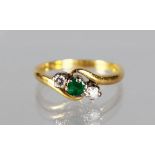 AN 18CT GOLD, EMERALD AND DIAMOND THREE STONE RING.