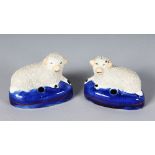 A PAIR OF STAFFORDSHIRE ENCRUSTED SHEEP PEN HOLDERS on blue bases. 3.25ins long.