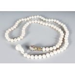 A PEARL NECKLACE with sapphire and mixed stone snake clasp.
