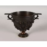 A BRONZE TWO HANDLED CUP with fruiting vines. 5ins high.