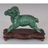 A CHINESE GREEN HARDSTONE MODEL OF A RAM, together with a fitted wire-inlaid wood stand, 3.1in