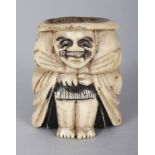 A JAPANESE MEIJI PERIOD STAGHORN NETSUKE OF DARUMA, squatting with his cloak closely drawn, 1.4in