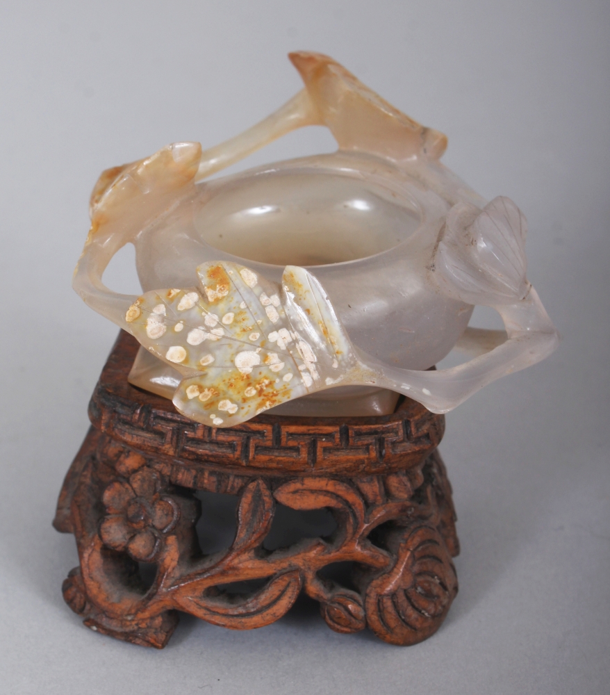 A SMALL CHINESE AGATE BRUSHWASHER, together with a fitted wood stand, carved in relief with