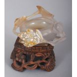 A SMALL CHINESE AGATE BRUSHWASHER, together with a fitted wood stand, carved in relief with