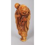 A JAPANESE EDO/MEIJI PERIOD STAINED IVORY NETSUKE OF A STANDING SENNIN, with cheerful expression and