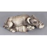 A SIGNED JAPANESE MEIJI PERIOD TOMOTADA STYLE IVORY NETSUKE OF A RECLINING OX, in the company of its