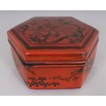 AN ORIENTAL MING STYLE OCTAGONAL SECTION RED LACQUER BOX & COVER, decorated with plum blossom in