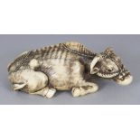 A GOOD JAPANESE MEIJI PERIOD TOMOTADA SCHOOL IVORY OKIMONO OF A RECLINING OX, carved with a