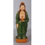 A LARGE CHINESE MING STYLE SANCAI GLAZED POTTERY FIGURE OF GUANYIN, standing on a lotus plinth and
