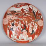 A JAPANESE KUTANI PORCELAIN DISH, circa 1900, painted with a panel of conversing Sennin, the base