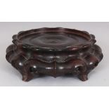 ANOTHER CHINESE CIRCULAR WOOD VASE STAND, supported on ruyi-form feet, 6.1in wide at widest point,