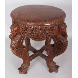 A 19TH/20TH CENTURY BURMESE CARVED AND PIERCED CIRCULAR WOOD STAND, supported on fish-head feet