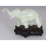 A CHINESE PALE CELADON BOWENITE CARVING OF A STRIDING ELEPHANT, together with a fitted wood stand,